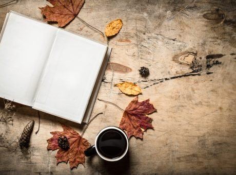 Autumn style. Open book with a hot Cup of coffee. Autumn style. Open book with a hot Cup of coffee. On wooden background.